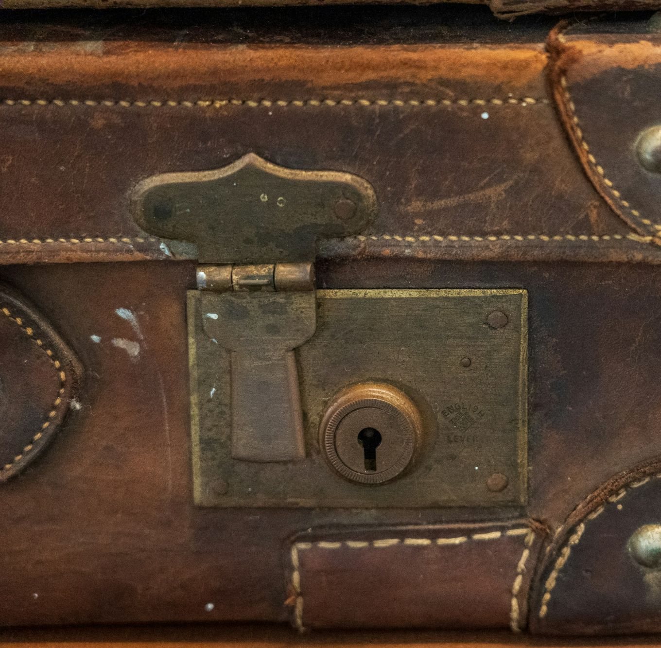 Detail of a vintage leather trunk's brass lock